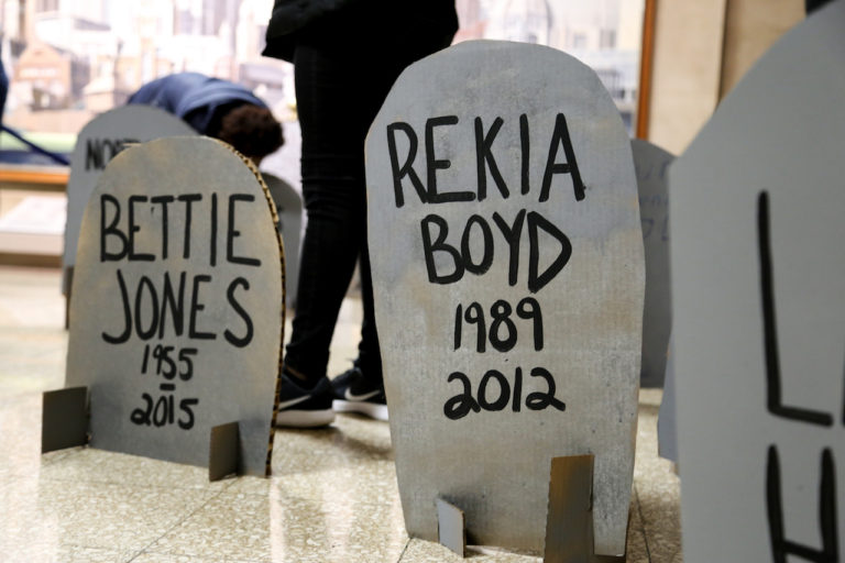 Youth organizers of #NoCopAcademy wrote the names of lives lost to police violence on makeshift headstones during a protest at City Hall