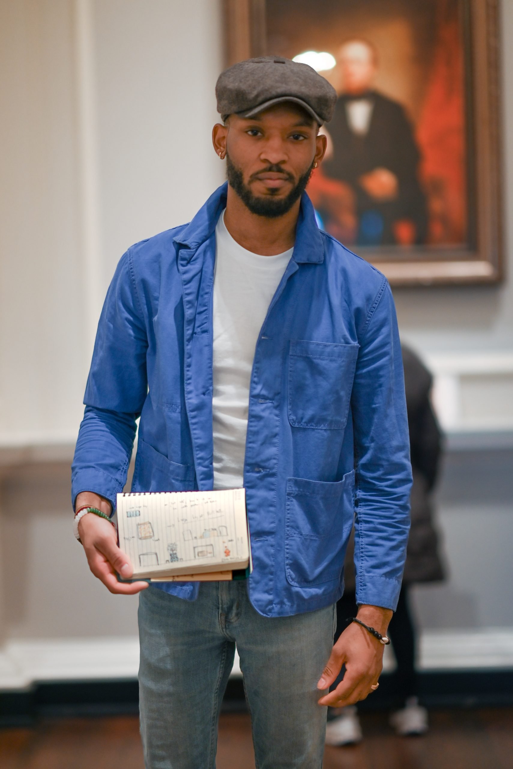 Jordan Campbell stands holding a rendering of Alt Space Chicago’s original rendering of his redemptive plastics program.