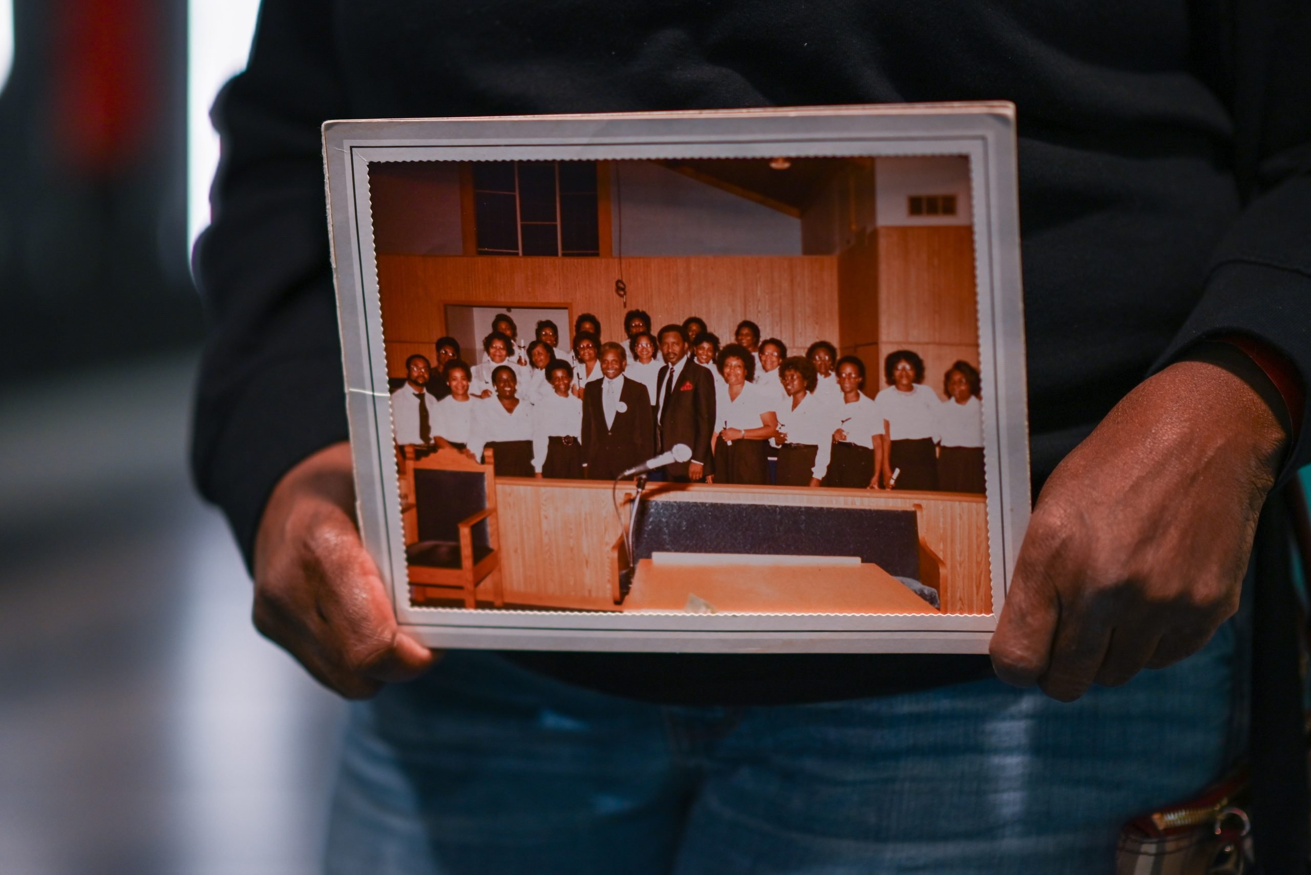 This artifact features a group of 25 people standing in the pews at church.