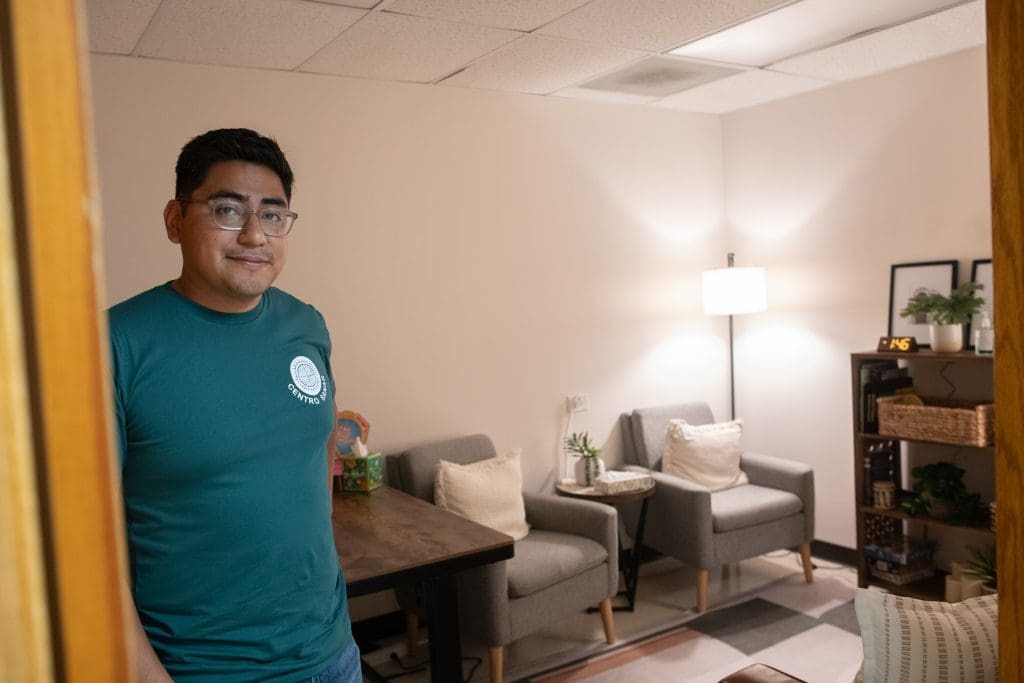 Edwin Martinez is standing in one of the family therapy rooms at Centro Sanar, where he is a co-founder and the executive director. Photo by Ash Lane for The TRiiBE®