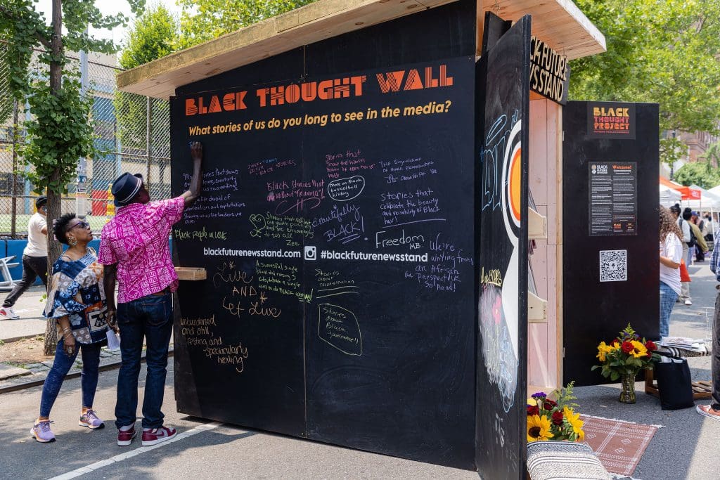 People interacting with the Black Future Newsstand exhibit. Photo courtesy of Bethanie Hines.
