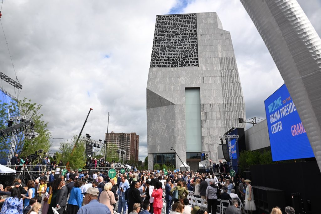 Invited attendees are beginning to gather in the John Lewis Plaza of the Obama Presidential Center, where its star-studded grand opening ceremony is taking place on June 18, 2026. Photo by Alexander Gouletas for The TRiiBE©